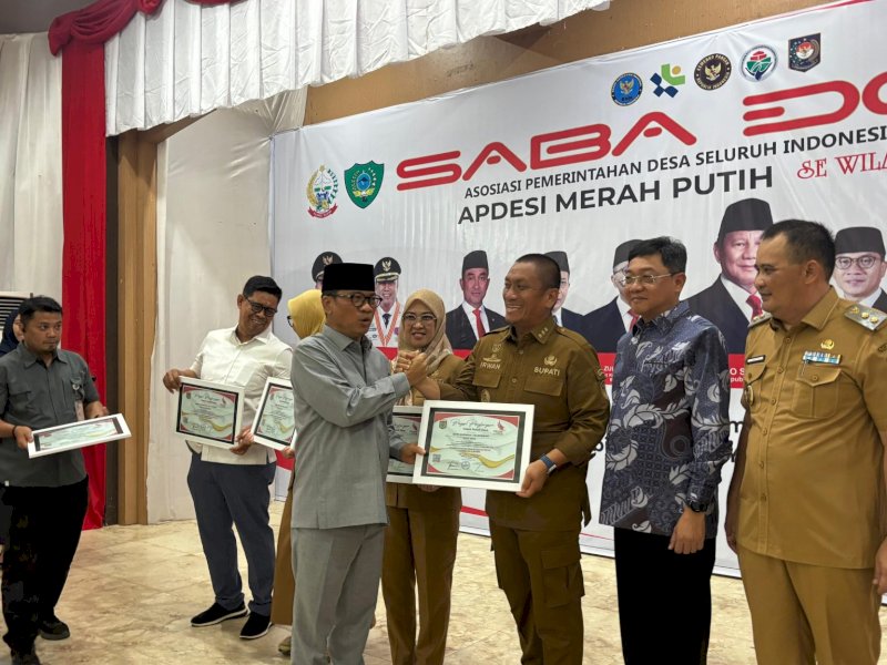 Bupati Luwu Timur, Irwan Bachri Syam, saat menerima penghargaan sebagai &ldquo;Kepala Daerah yang Peduli Desa&rdquo; pada kegiatan Saba Desa, Asosiasi Pemerintah Desa Seluruh Indonesia (APDESI) Merah Putih se-Indonesia Timur di Gedung Serbaguna Pemkab Maros, Selasa (02/12/2025). @Jejakfakta/dok. ikp-humas/kominfo-sp
