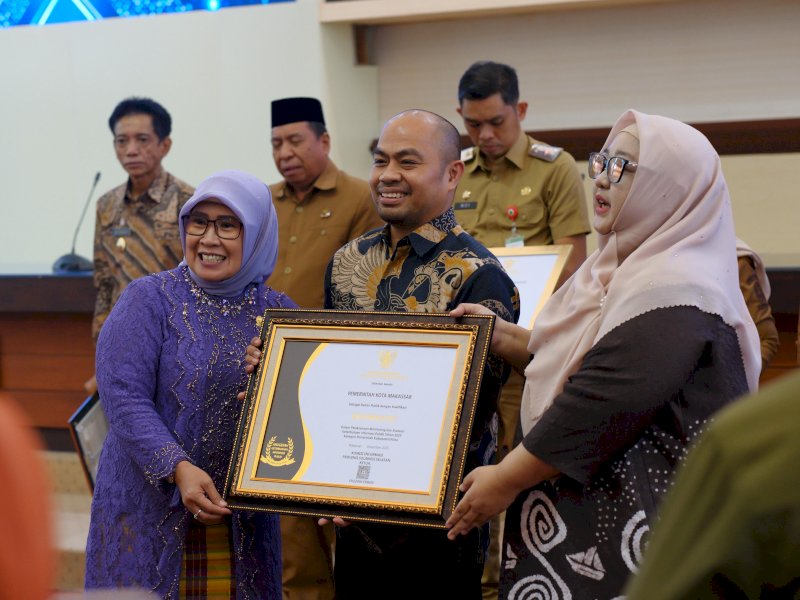 Kepala Dinas Komunikasi dan Informatika (Diskominfo) Kota Makassar, Dr. M. Roem, saat menerima penghargaan predikat "Informatif" Anugerah Keterbukaan Informasi Publik 2025 di Kantor Gubernur Sulsel, Senin (22/12/2025). @Jejakfakta/dok. Humas Pemkot Makassar