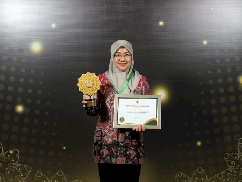 Kepala Dinas Kesehatan Kota Makassar, dr. Nursaidah Sirajuddin, saat menerima penghargaan UHC kategori Pratama. @Jejakfakta/dok. Humas Pemkot Makassar