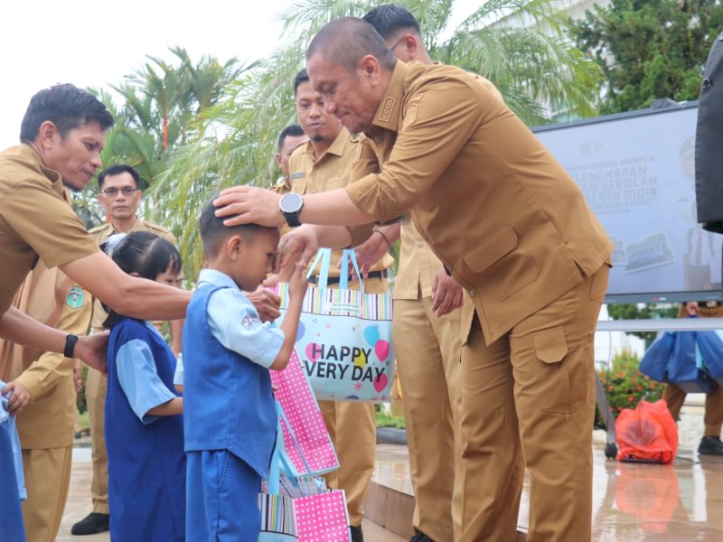 Penyerahan bantuan paket seragam sekolah gratis oleh Bupati Irwan Bachri Syam saat apel pagi pertama pasca-libur sekolah dan kerja, di halaman Kantor Bupati, Senin (30/3/2026). @Jejakfakta/dok. Humas Pemkab Lutim