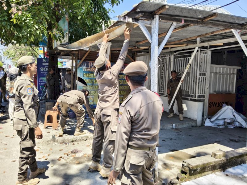 Satpol PP menertibkan sekaligus merelokasi 27 lapak Pedagang Kaki Lima (PKL) yang selama bertahun-tahun berdiri di atas fasilitas umum (fasum), seperti trotoar dan saluran drainase, Rabu (15/4/2026). @Jejakfakta/dok. Humas Pemkot Makassar
