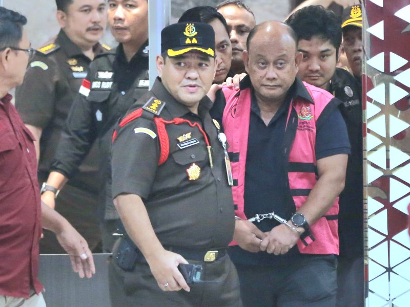 Dadan terlihat mengenakan rompi tahanan berwarna merah muda dan tidak menyampaikan sepatah kata pun saat digelandang. @jejakfaktacom/Ist.
