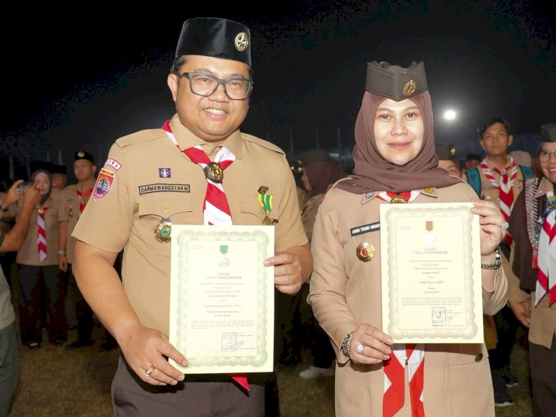 Wakil Ketua Majelis Pembimbing Cabang (Mabicab) Gerakan Pramuka Gowa, Darmawangsyah Muin, bersama Andi Tenri Indah menerima penghargaan dari Kwartir Nasional (Kwarnas) Gerakan Pramuka dalam rangkaian peringatan Hari Pramuka Tingkat Nasional ke-65 Tahun 2026, di Lapangan Kempi 2, Bumi Perkemahan dan Graha Wisata (Buperta) Cibubur, Jakarta Timur, Kamis (13/8/2026) malam. @Jejakfakta/dok. Humas Pemkab Gowa