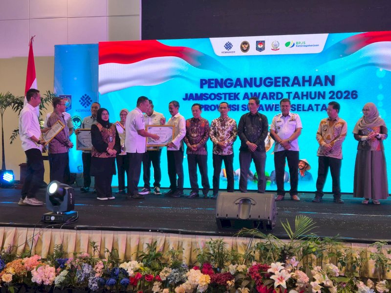 Penjabat (Pj) Sekretaris Daerah Provinsi Sulawesi Selatan, Andi Winarno Eka Putra, saat memberikan penganugerahan Jamsostek Award 2026 Sulsel kepada Kepala Dinas Ketenagakerjaan dan Transmigrasi (Disnakertrans) Kabupaten Gowa, Muhammad Sabir, di Phinisi Ballroom, Claro Hotel Makassar, Rabu (21/10/2026). @Jejakfakta/dok. Humas Pemkab Gowa