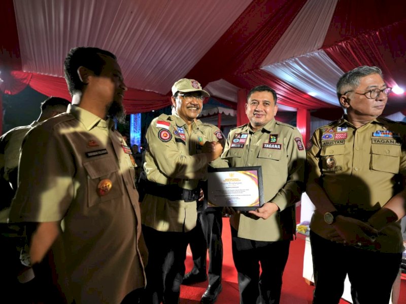 Wali Kota Makassar, Munafri Arifuddin, menerima piagam penghargaan dari Menteri Sosial Republik Indonesia, Saifullah Yusuf, atas dedikasi, loyalitas, dan pengabdiannya dalam upaya penanggulangan bencana, mulai dari tahap prabencana, tanggap darurat, hingga pascabencana, di halaman Kantor Dinas Perhubungan Sulsel, Senin (26/10/2026) malam. @Jejakfakta/dok. Humas Pemkot Makassar